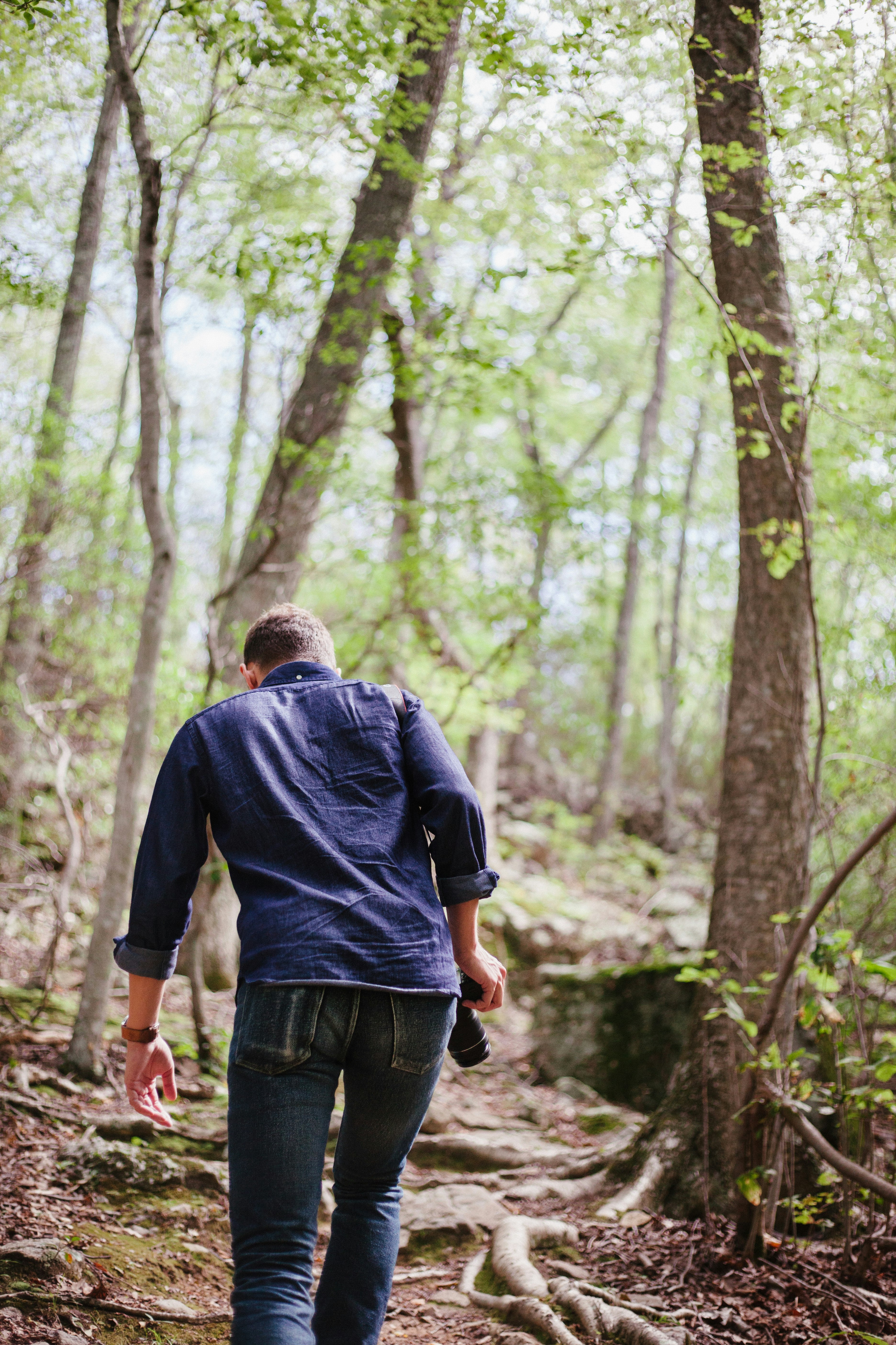 man in black jacket walking on forest during daytime